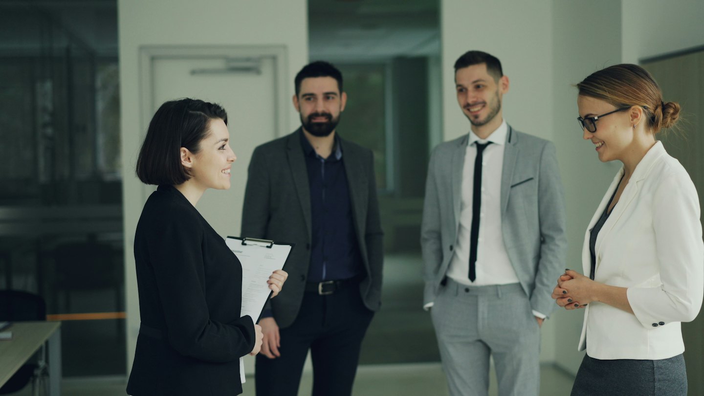 Zakelijke professionals die ideeën bespreken in een moderne kantoorhal.